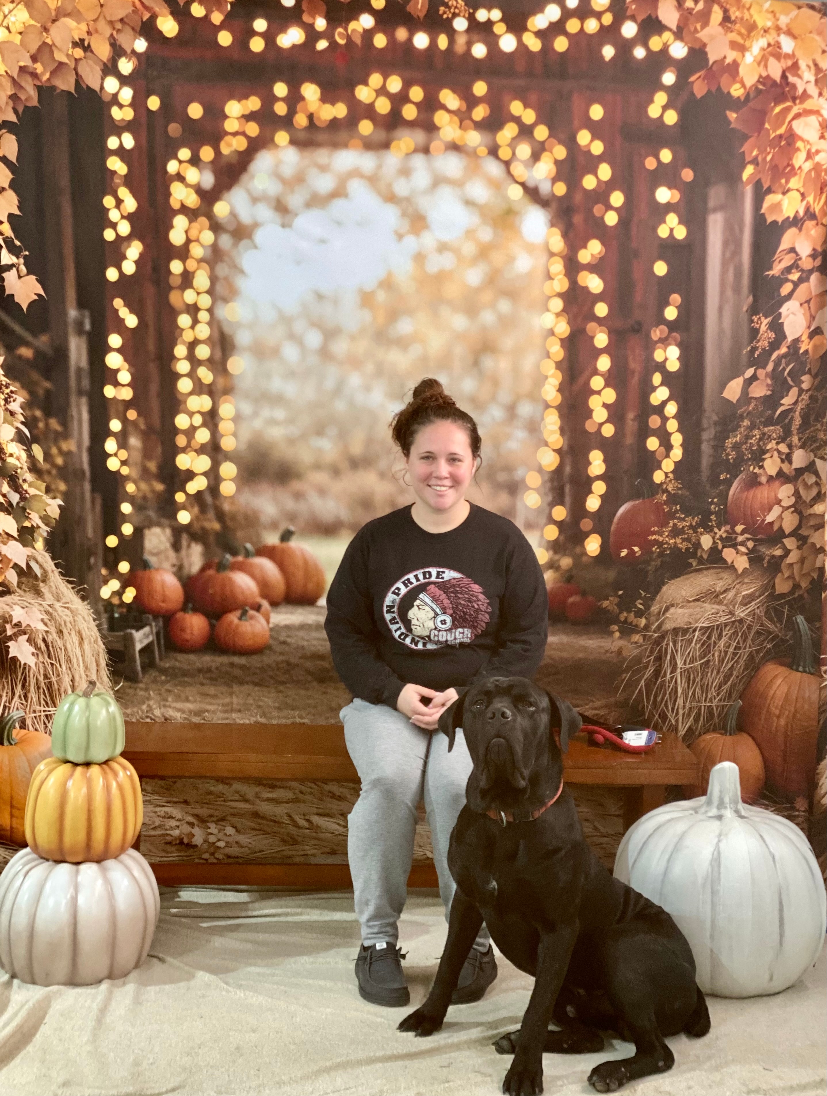 Woman with black Cane Corso in autumn harvest photo setting