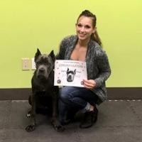 Woman with Cane Corso holding graduation certificate