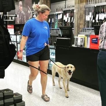 Community graduate with yellow lab in store