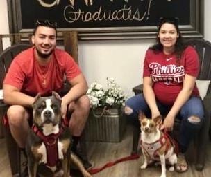Family graduation photo with two dogs