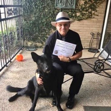 Priest — man holding Intermediate Obedience certificate with black dog at Haven banner