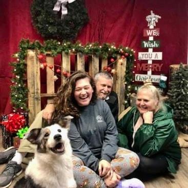 Rory — family laughing with Australian Shepherd at Christmas photo backdrop