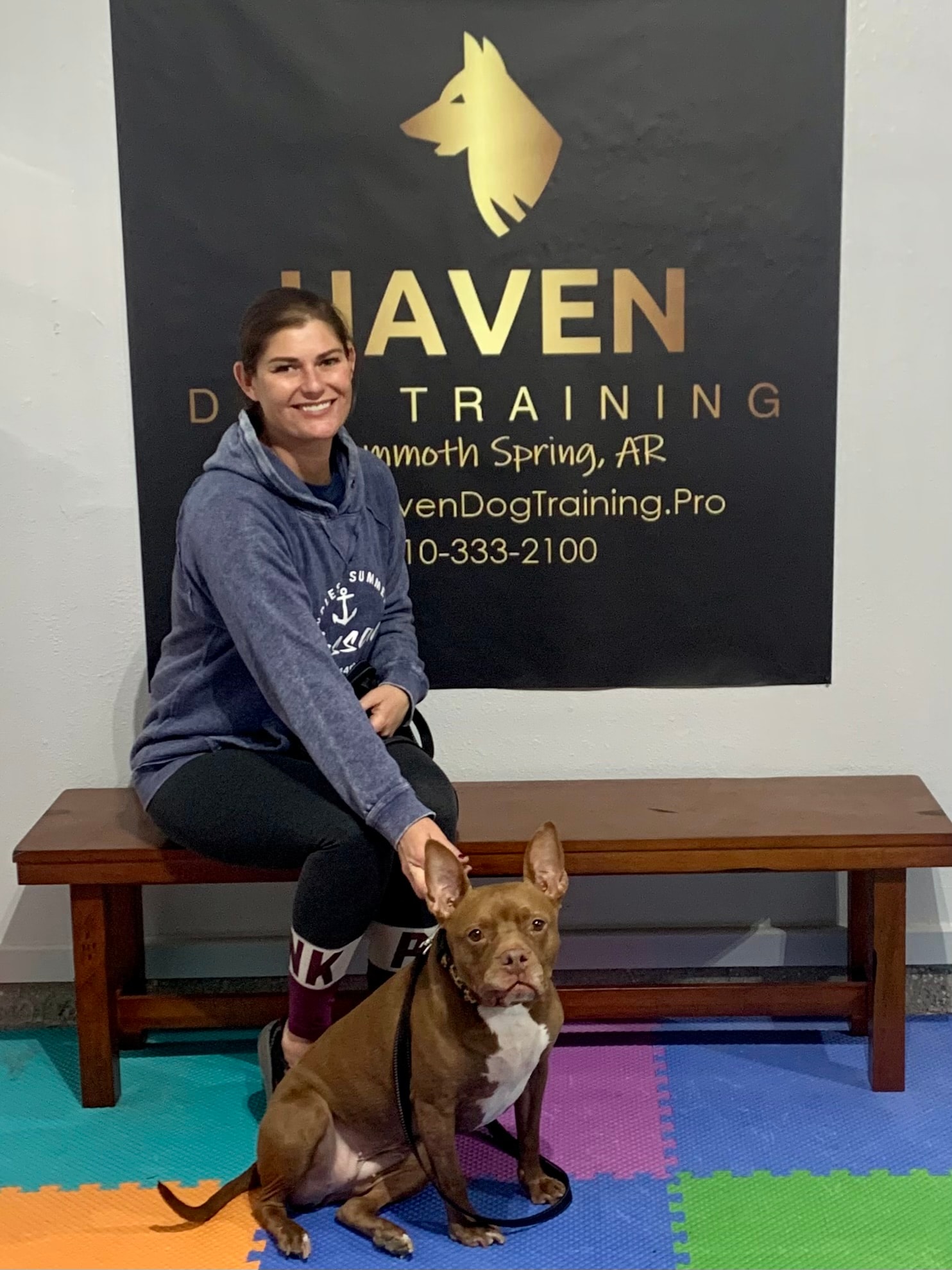 Ruby — woman with red Pit Bull sitting at Haven Dog Training banner