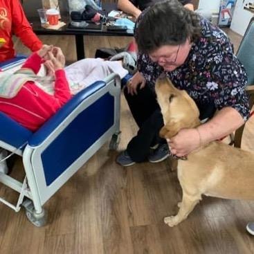Therapy dog Yeti visiting with resident at care facility