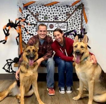Couple posing with two yellow Labradors at Haven Dog Training